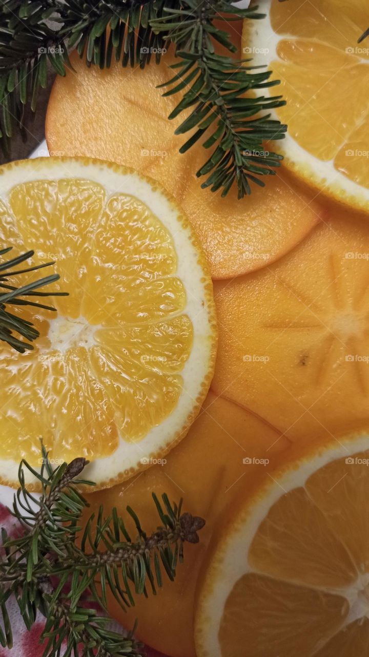 Christmas mood. Persimmons, oranges and Christmas tree