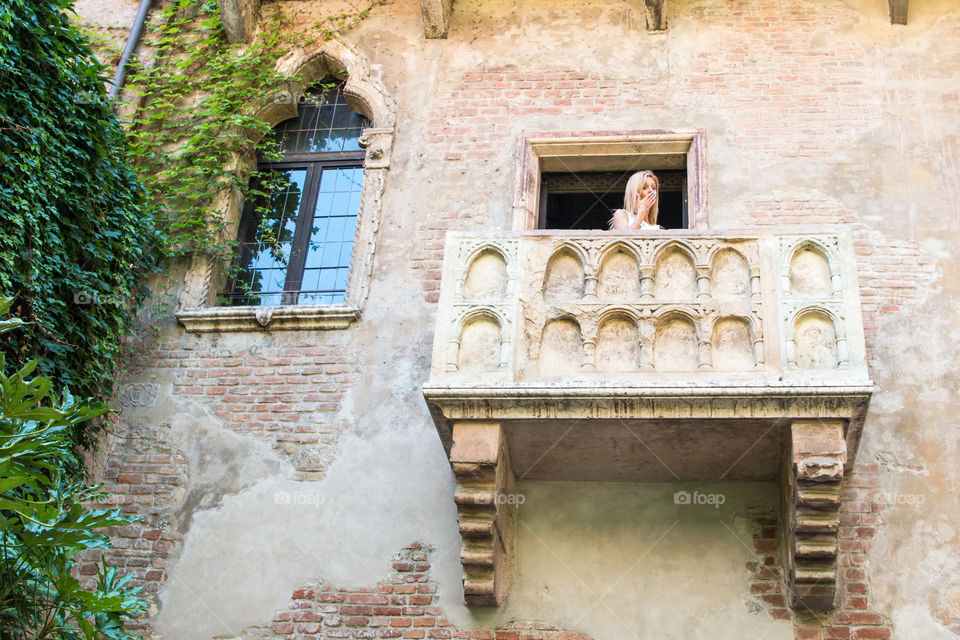 Young Beautiful Blonde Woman Send Kisses From Romeo And Juliet's Balcony House In Verona Italy
