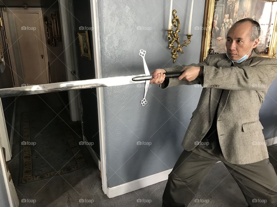 Ready for action as he stands in a posture with the large, lengthy blade of a Scottish claymore protruding outward.