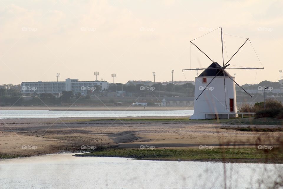 Lonely windmill in the middle os a river 