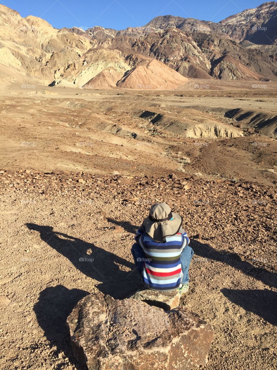 Desert, a young explorer enjoying the view of desert landscape. People from behind