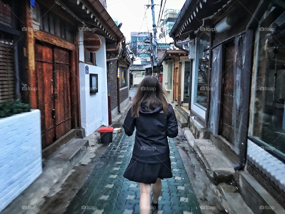 Woman walking through Korean alley