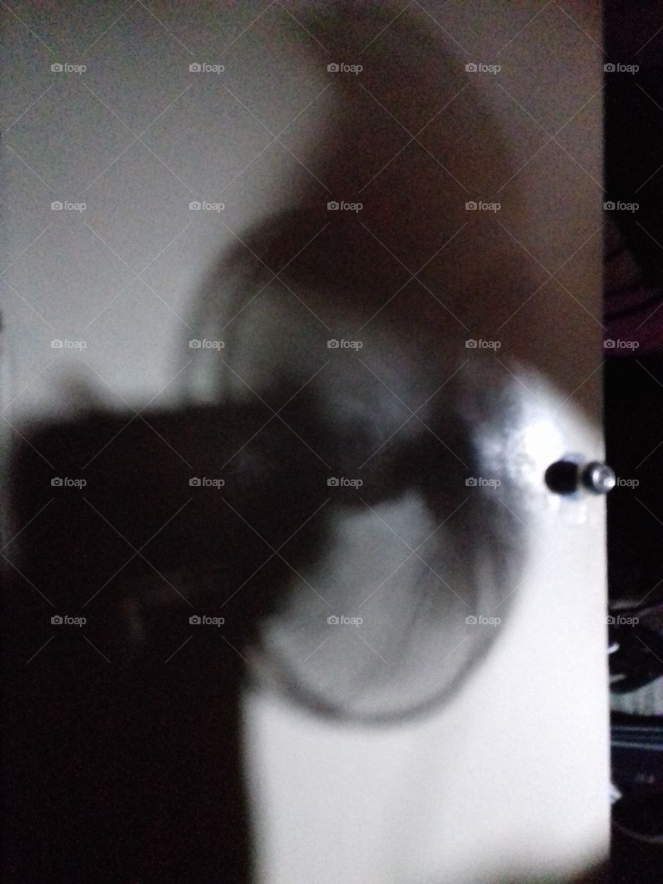 shadow of my electric fan on the half-open door on a warm night