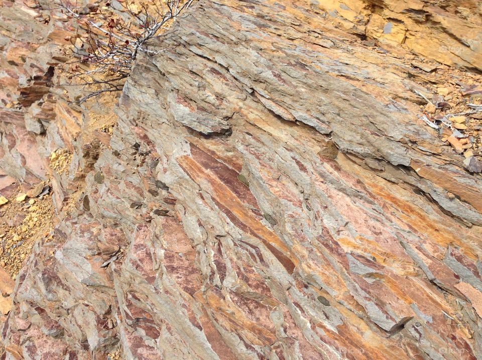 Rough layers of beautiful reddish brown rock on a hillside in Central Oregon on a sunny day. 