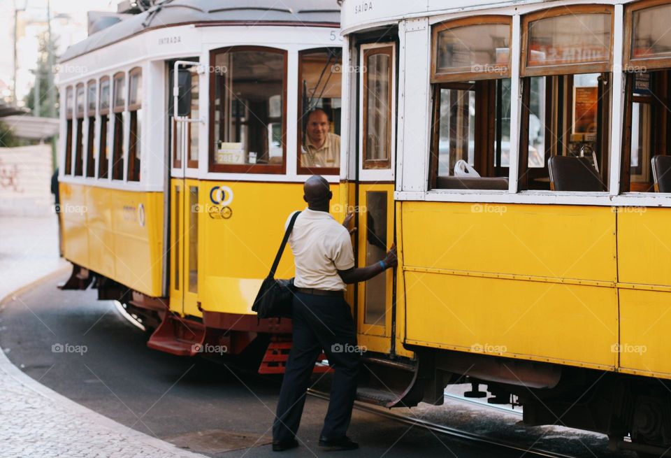 Lisbon street with old historical buildings and yellow trams. Traditional yellow tramp in Lisbon, Portugal.