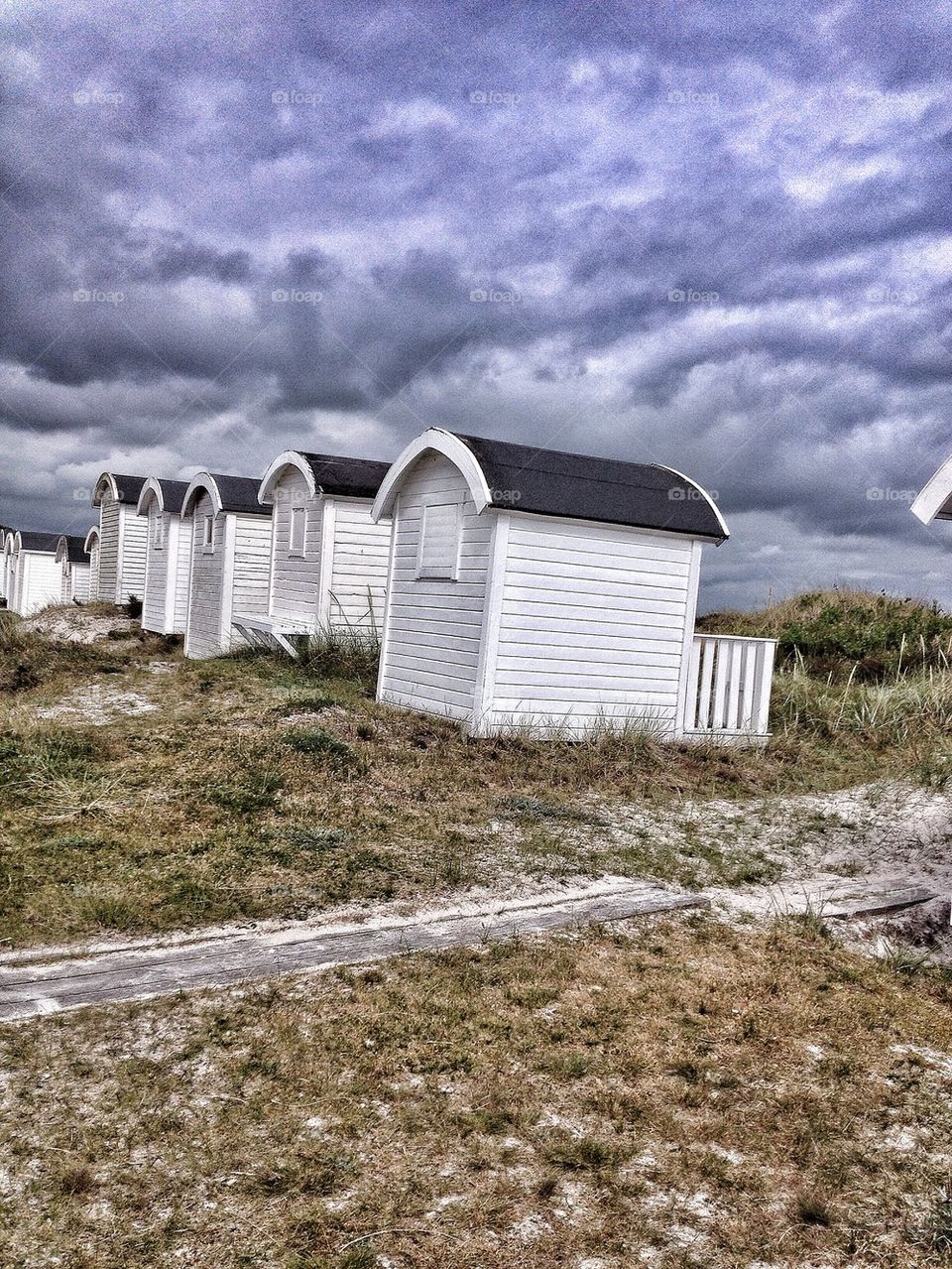 Beach huts in dark clouds