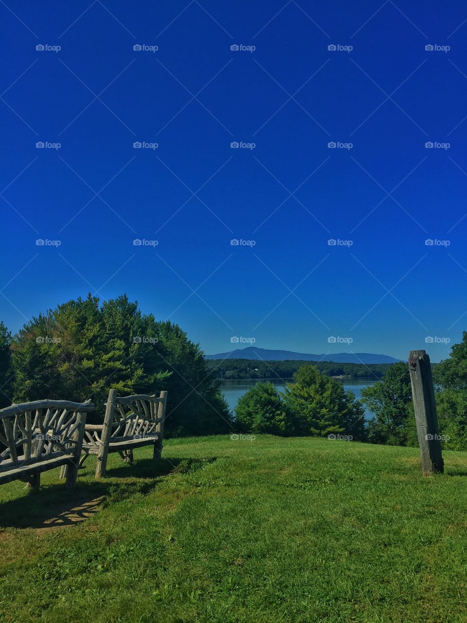 Hill over the river. A hill with rustic wooden benches overlooking the Hudson River in Rhinebeck, New York. 