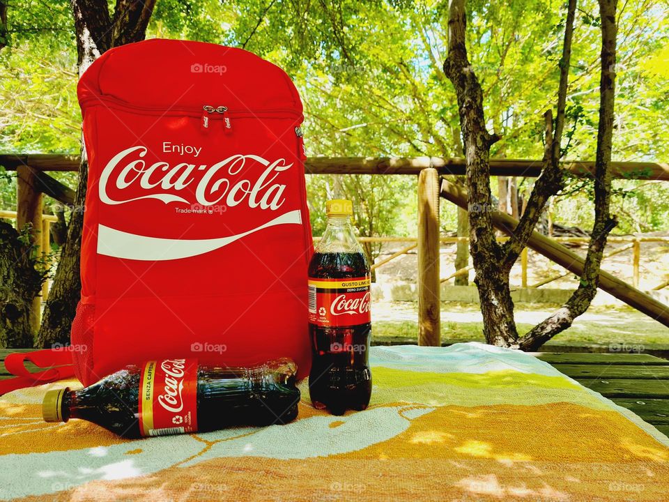 Coke bottles on picnic table in the woods