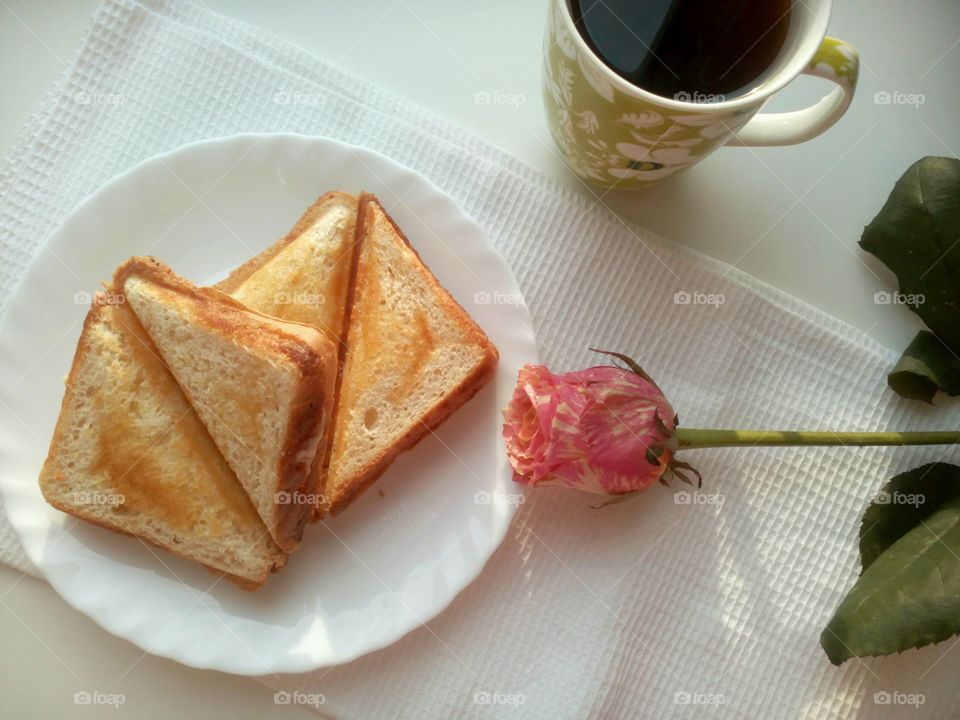 Cup of coffee with bread in plate