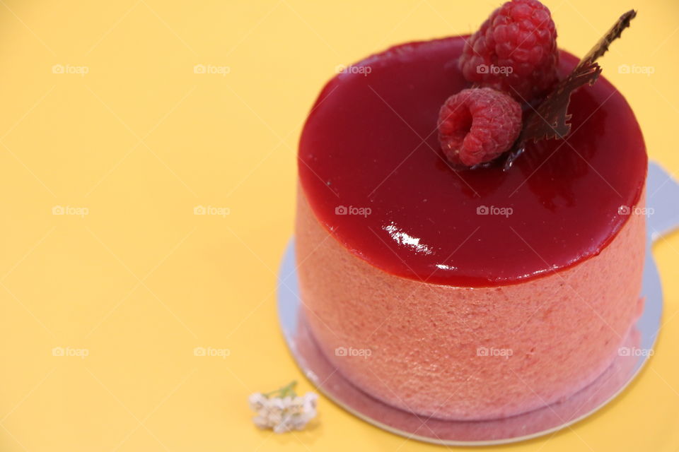 Raspberry mousse / sweet delight, laying on a yellow table top