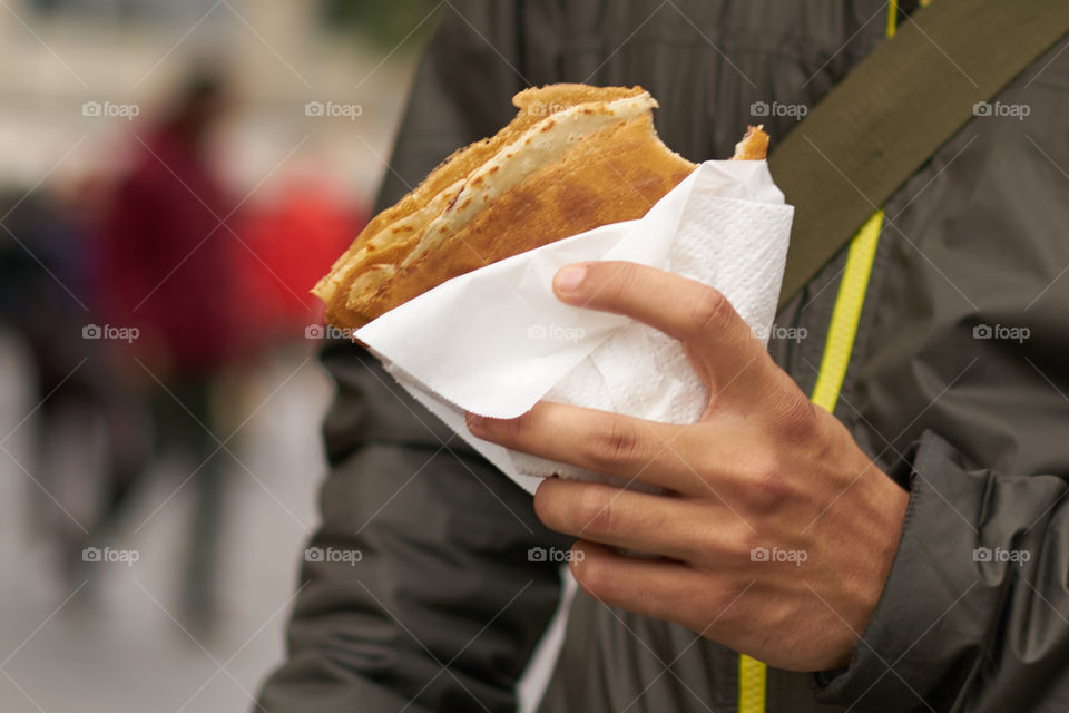 Close-up of man eating crepe