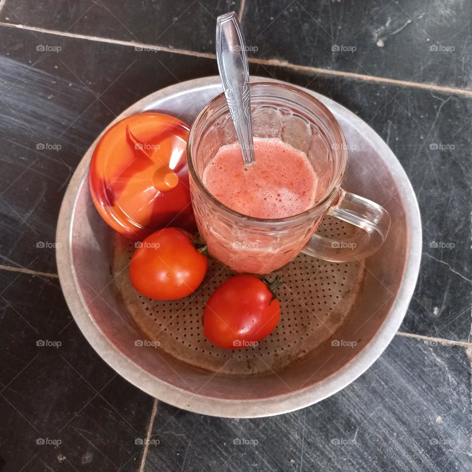 Tomato juice whose main ingredients are white sugar tomatoes and ice cubes