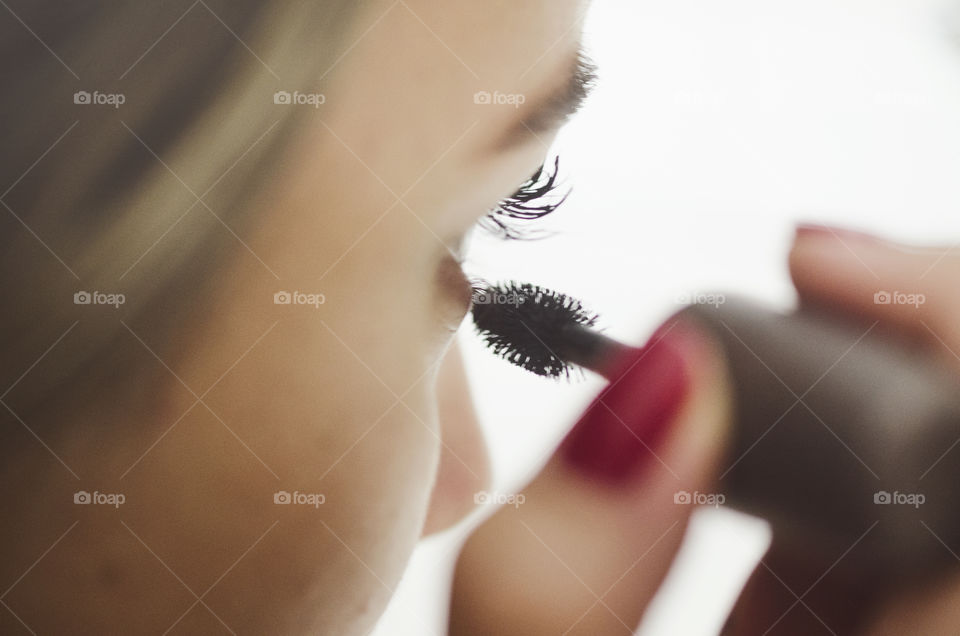 Woman putting mascara on 
