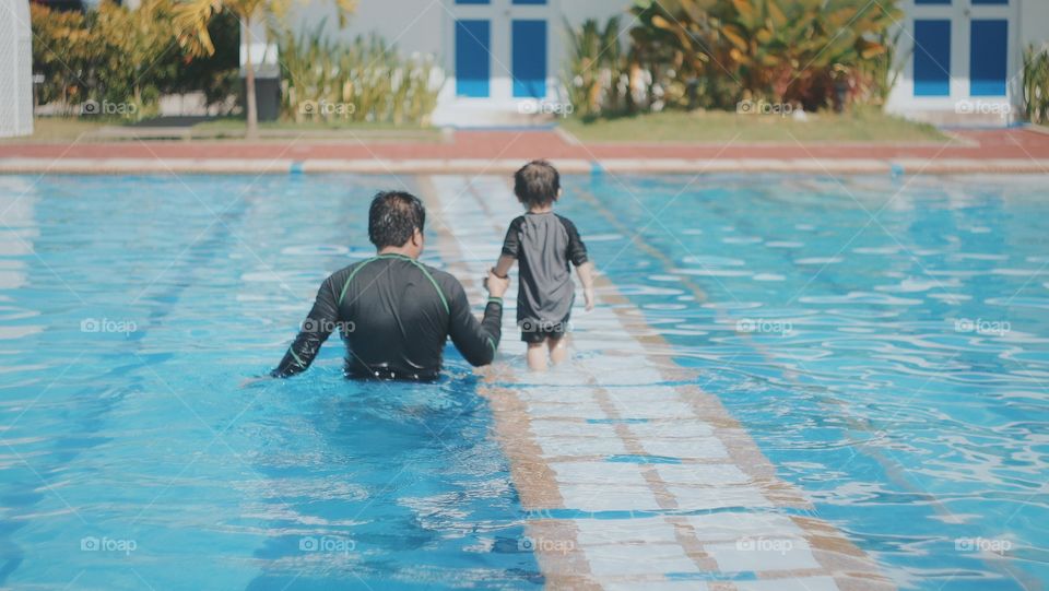Father and son having fun in the pool.