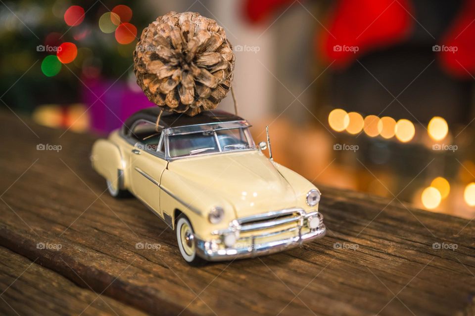 Toy car with pine cone on wooden table