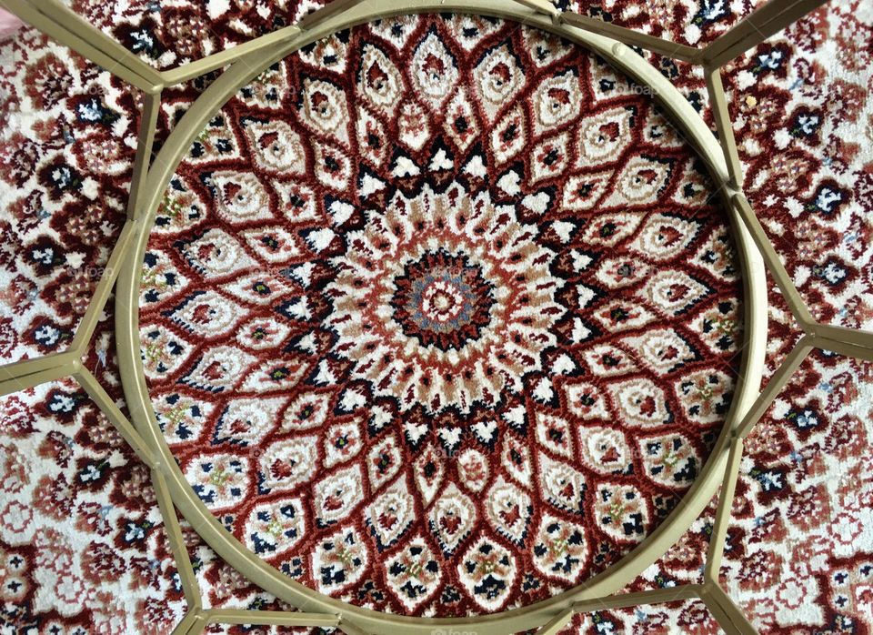 Golden metal circular table in the middle of the carpet. 