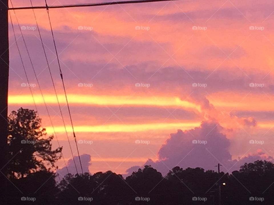 A stunning pink orange sunset with two prominent yellow streaks in it.