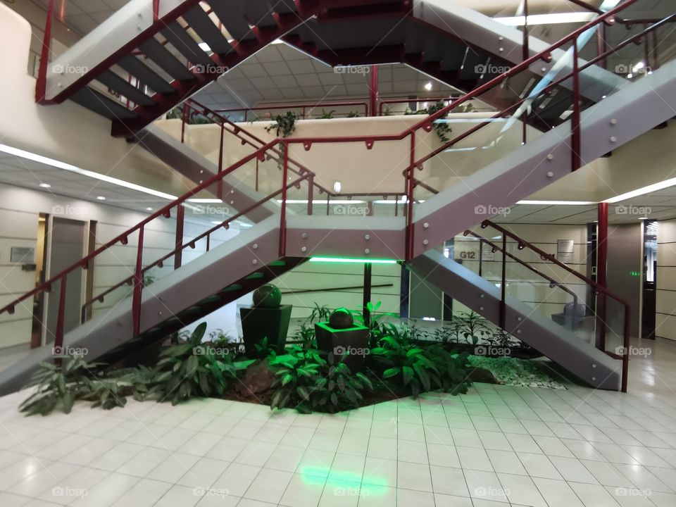 Staircases in the foyer with decorations underneath.