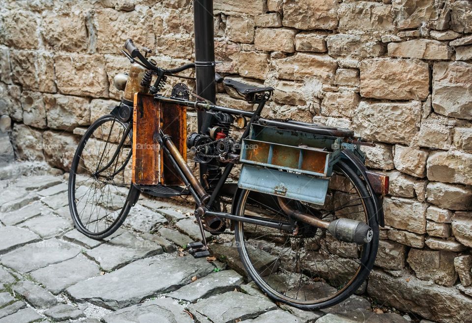 Vintage bicycle leaning on stone wall in alley