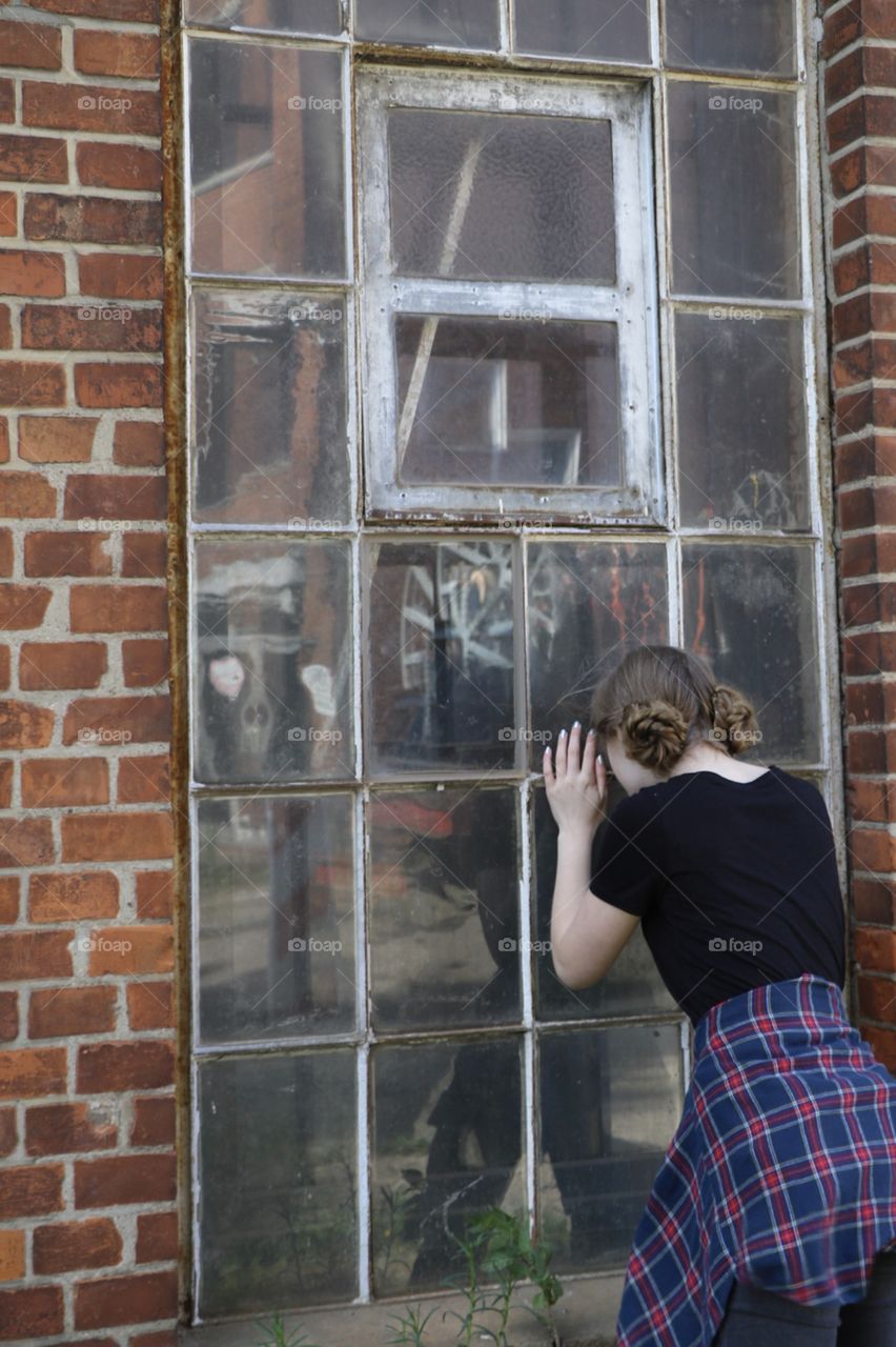 Girl looking through factory window