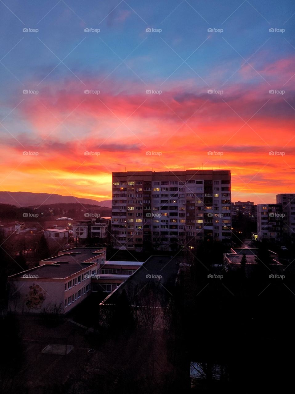 A picturesque scenery of the sunset clouds in amazing colours like orange, red, purple and pink with the apartment buildings beneath in the capital of Bulgaria