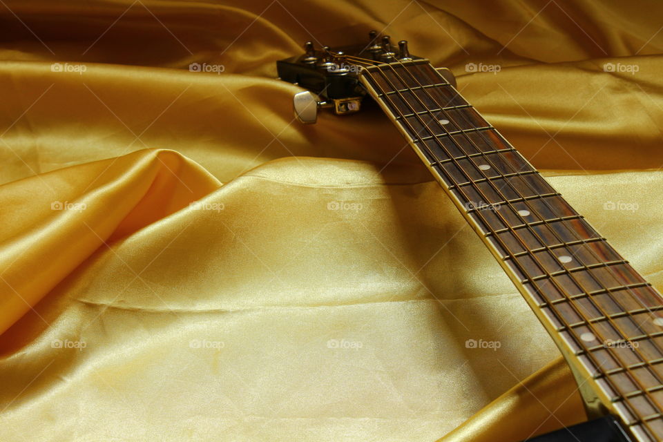 acoustic guitar on Golden textile