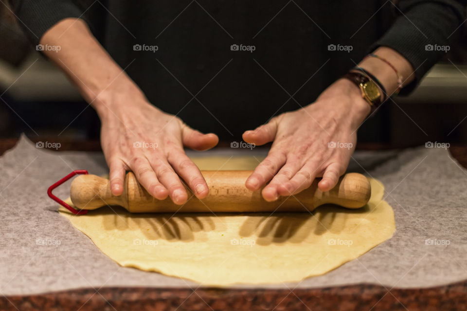 Woman rolling bread dough with rolling pin