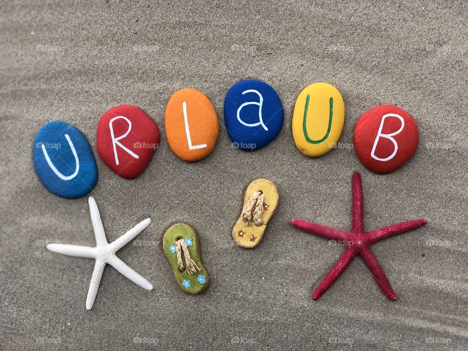 Urlaub, holiday in german language with colored stone letters