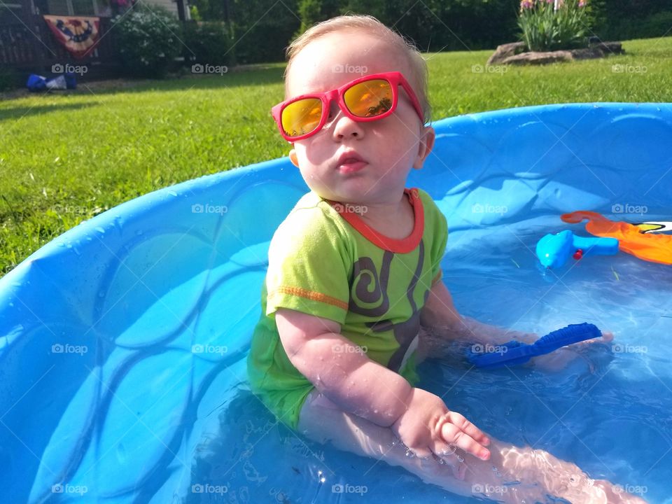 Cute baby in pool with sunglasses