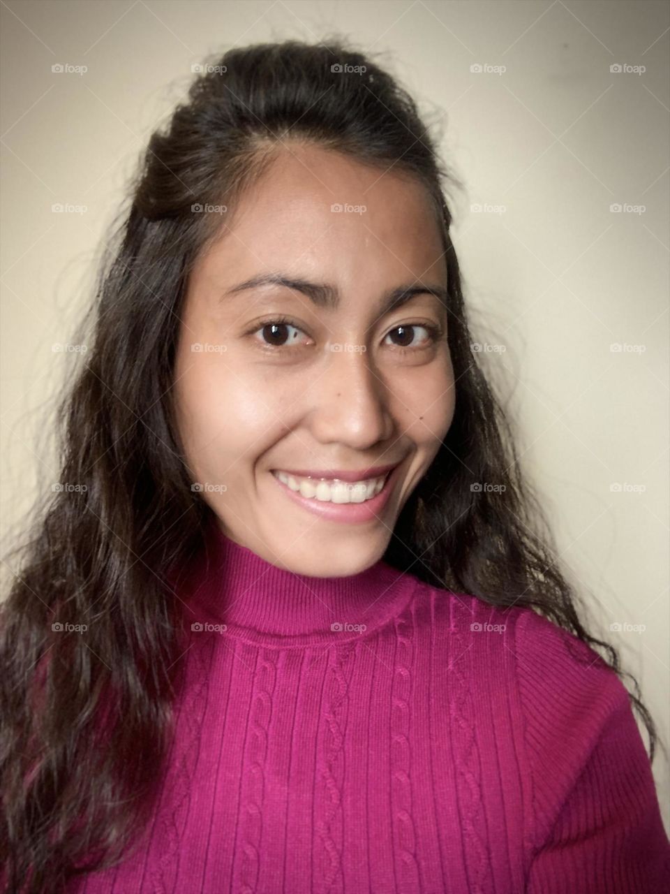 Smiling woman with wavy hair and pink clothes 