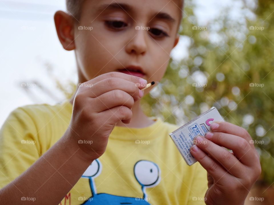 Close-up of boy with match box