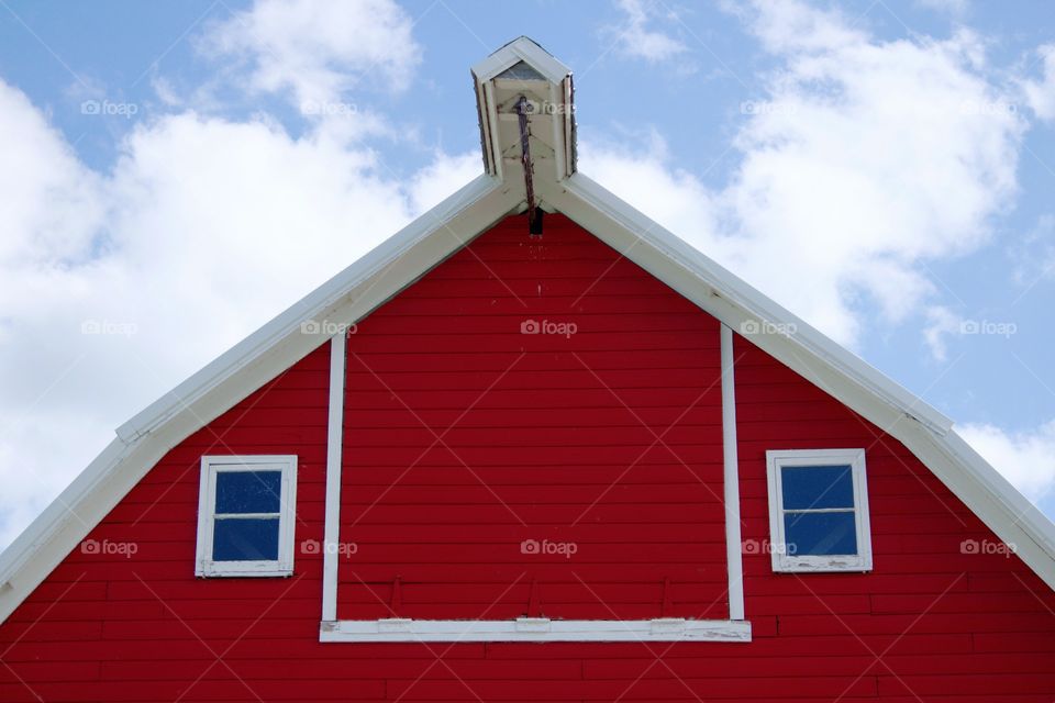 A big red barn against a beautiful summer sky