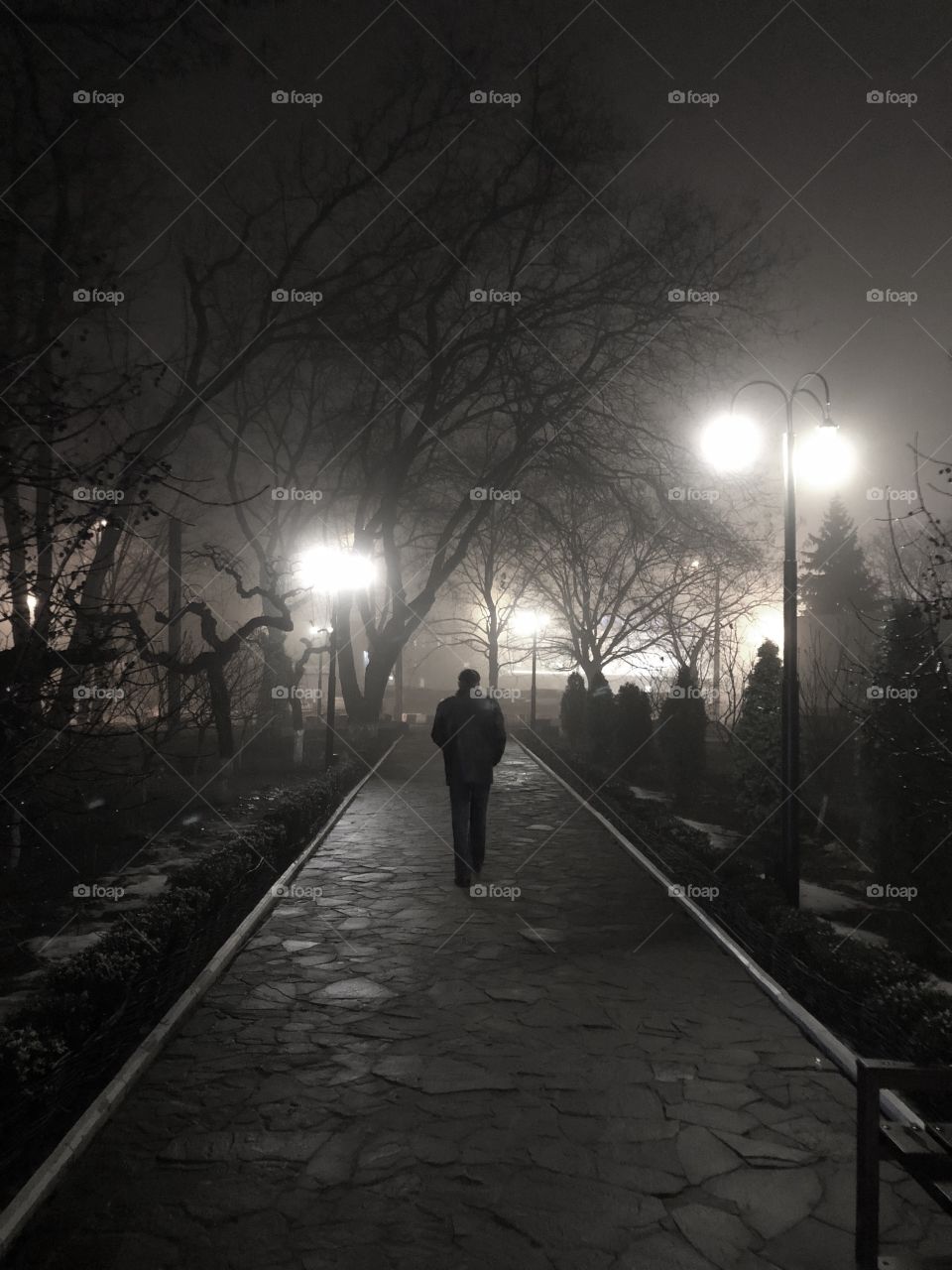 Alone person walking into the foggy night 