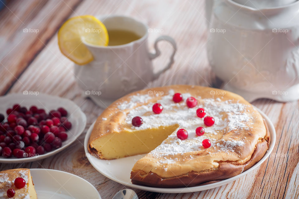 Cheesecake with cranberries and sugar on wooden background