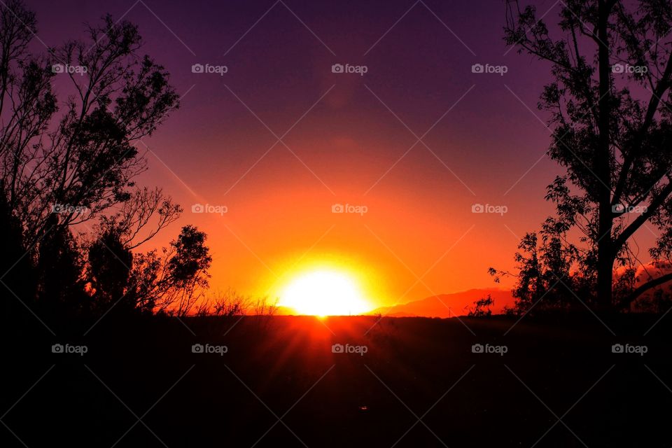 This photo captures a beautiful Californian sunrise on Christmas morning over a landscape of hills and trees.