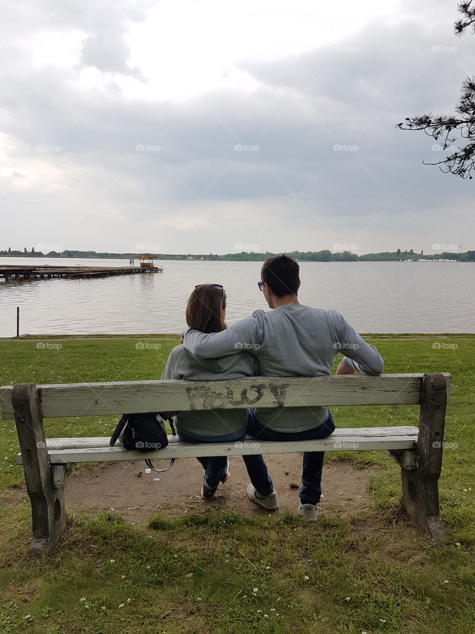 romantic couple on the bench besides lake