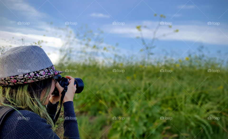 lady holding dslr camera, taking a photo of the blooms in spring