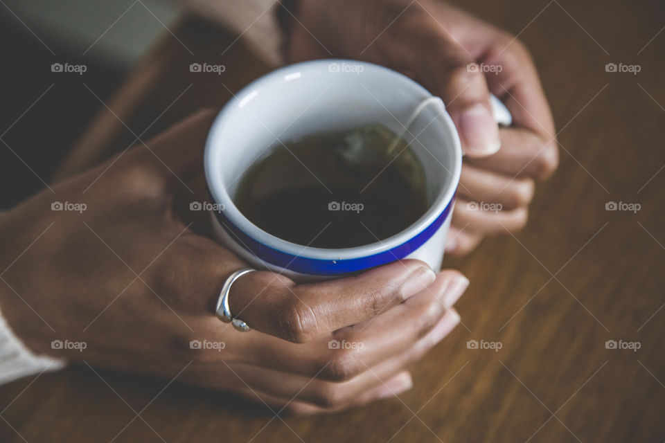 Hand holding tea cup with teabag