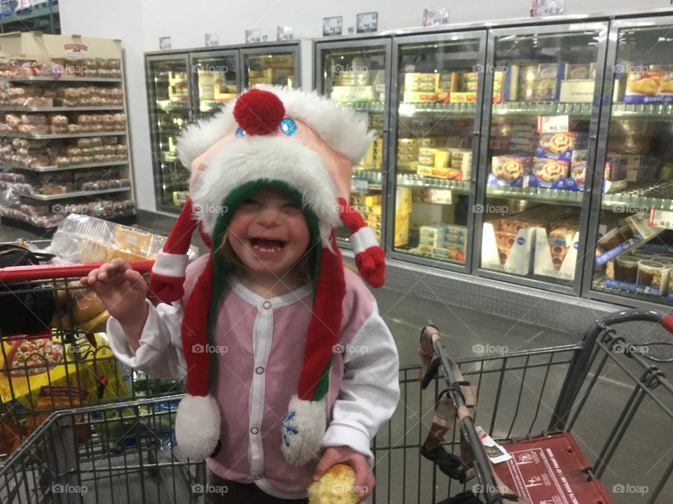 Little girl with Down syndrome shopping with silly hat