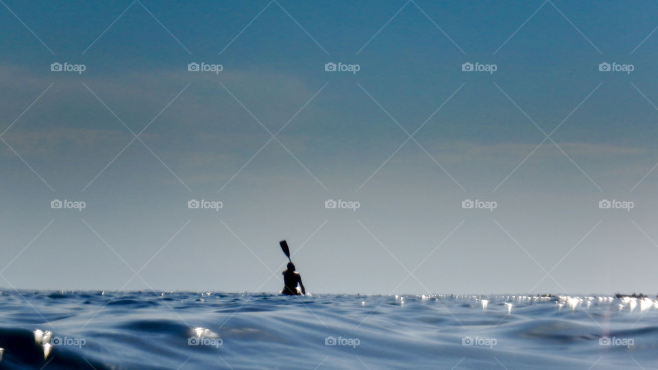 woman with a kayak on the nig blue sea