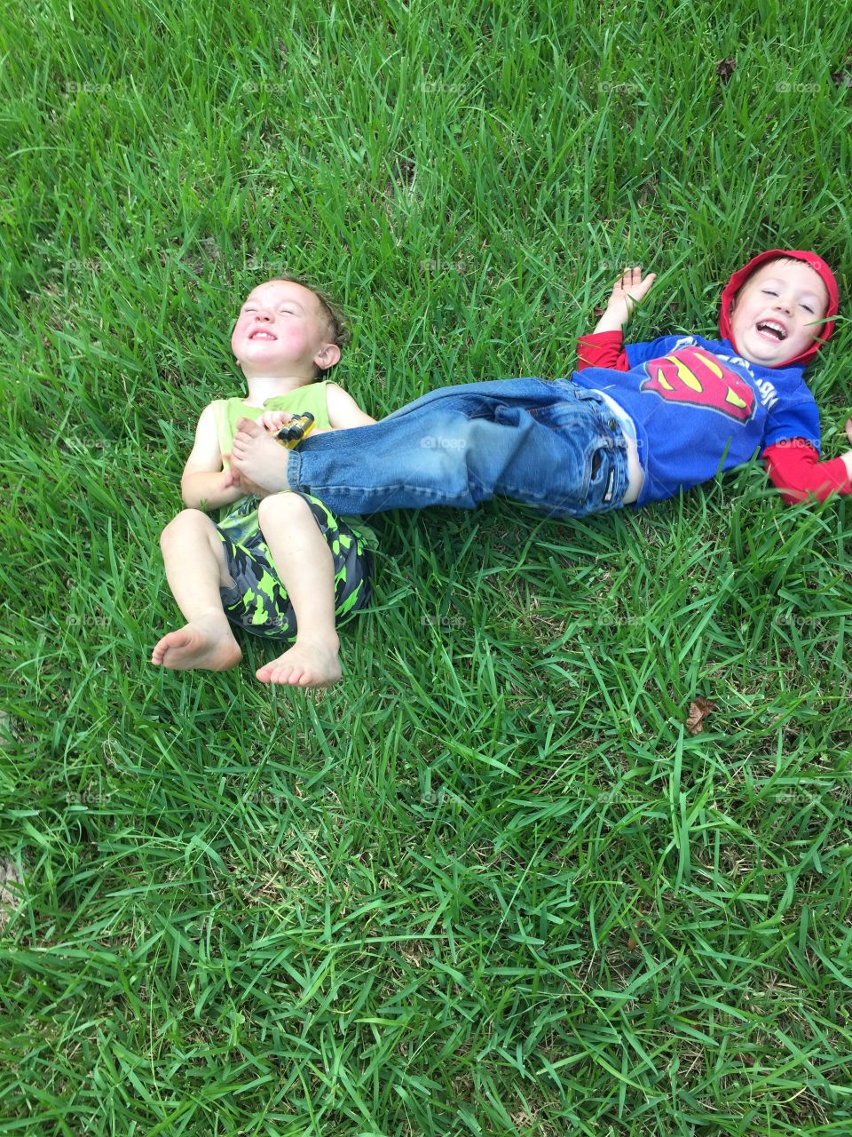 Boys playing in the grass in the front yard having lots of fun