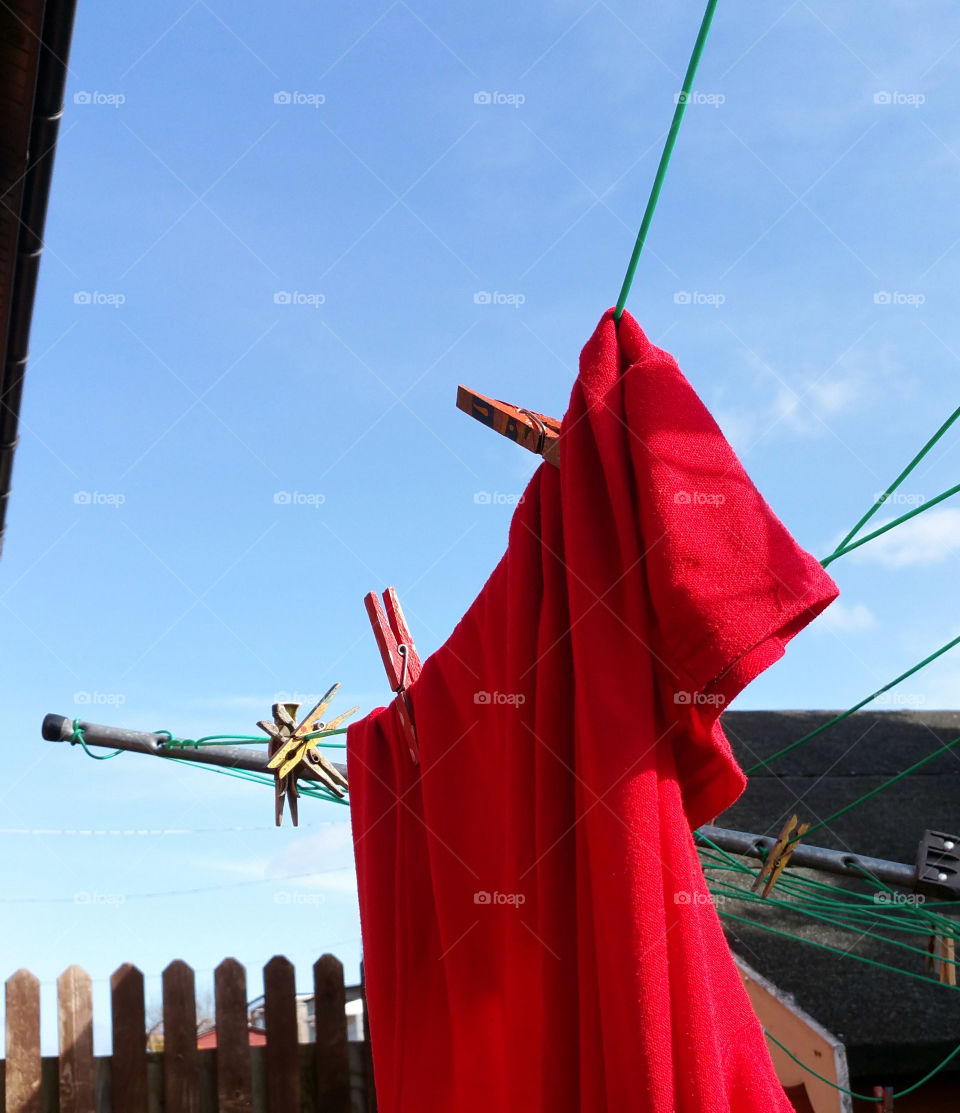 Red shirt and red pegs, blue sky