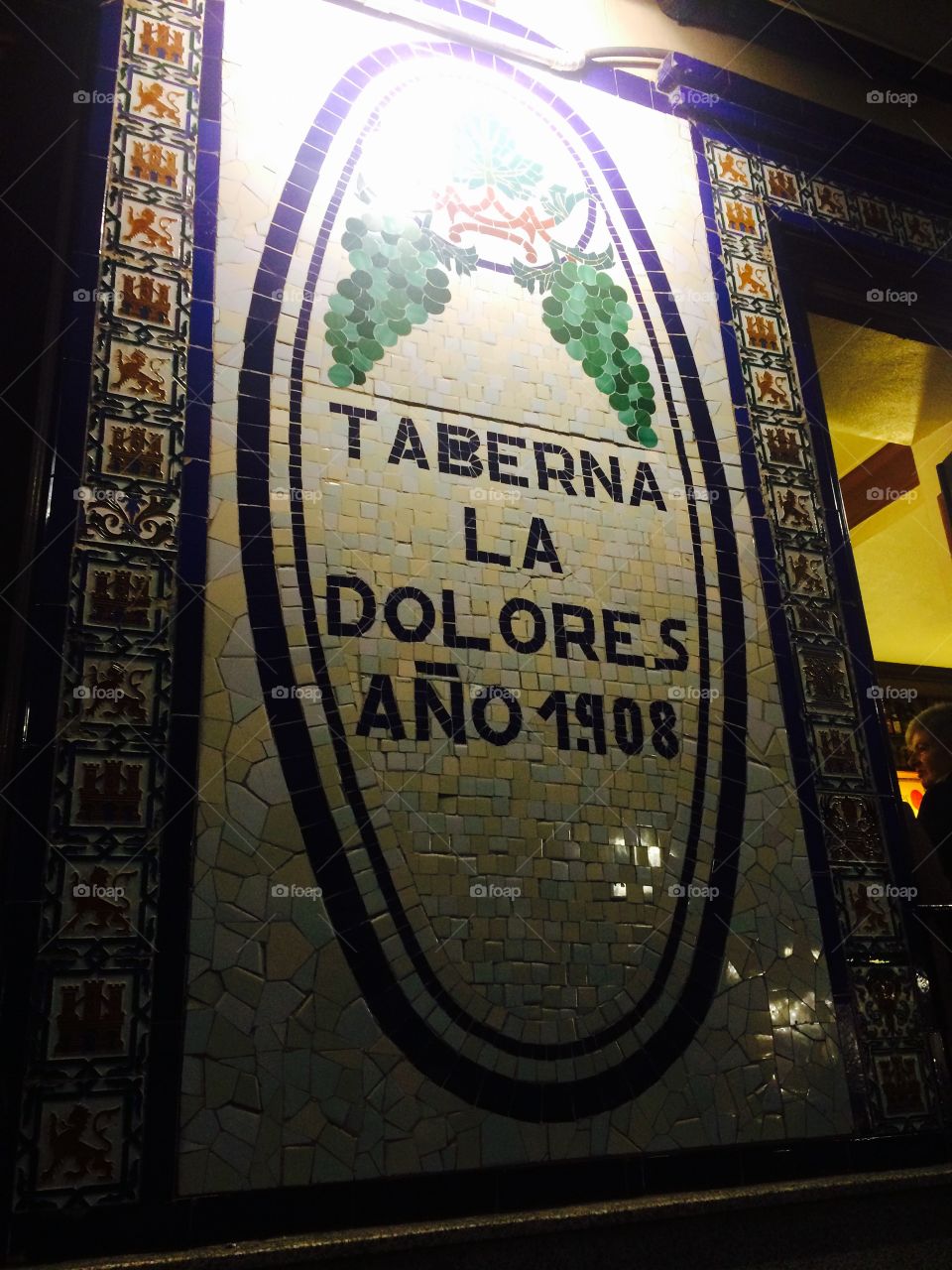 Name of a popular pub in Madrid city centre painted on ceramic tiles and displayed at the entrance 