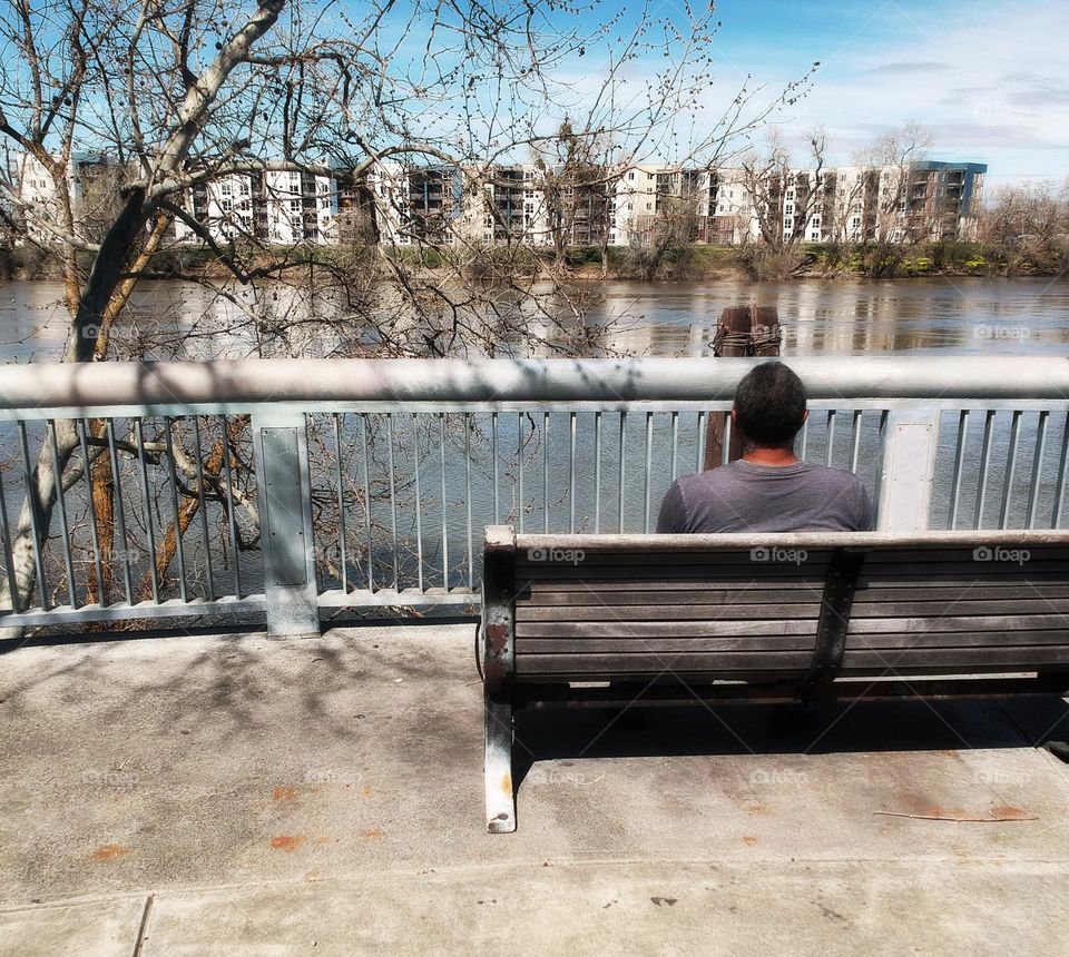 Enjoying the view on a park bench at the riverfront in the city of Sacramento California
