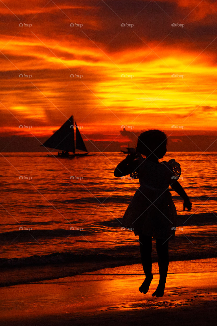 Silhouette of little girl on the sea