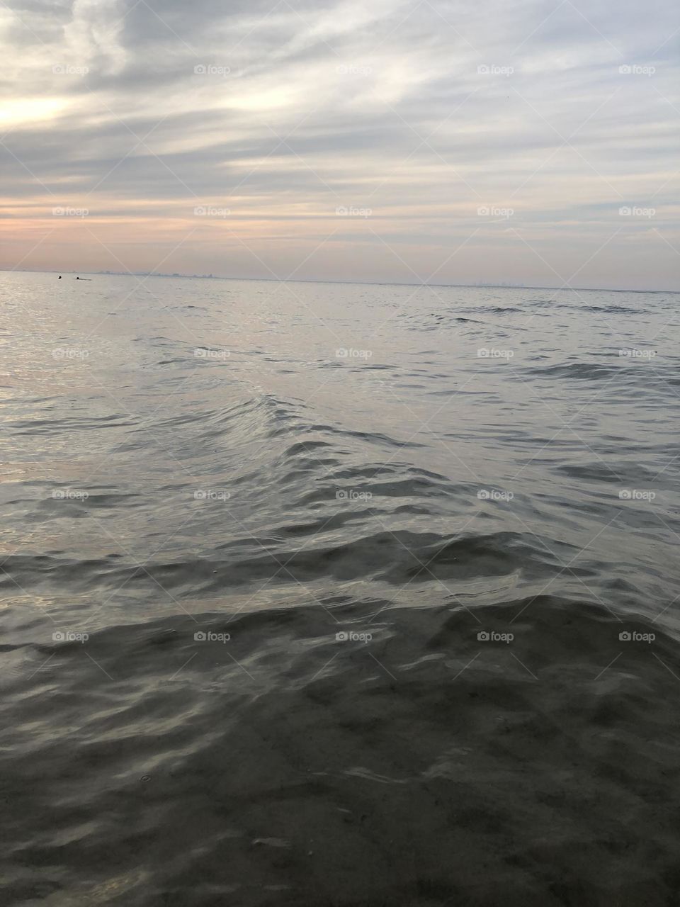 I the lake taking pictures of forming of a wave at sunset. 