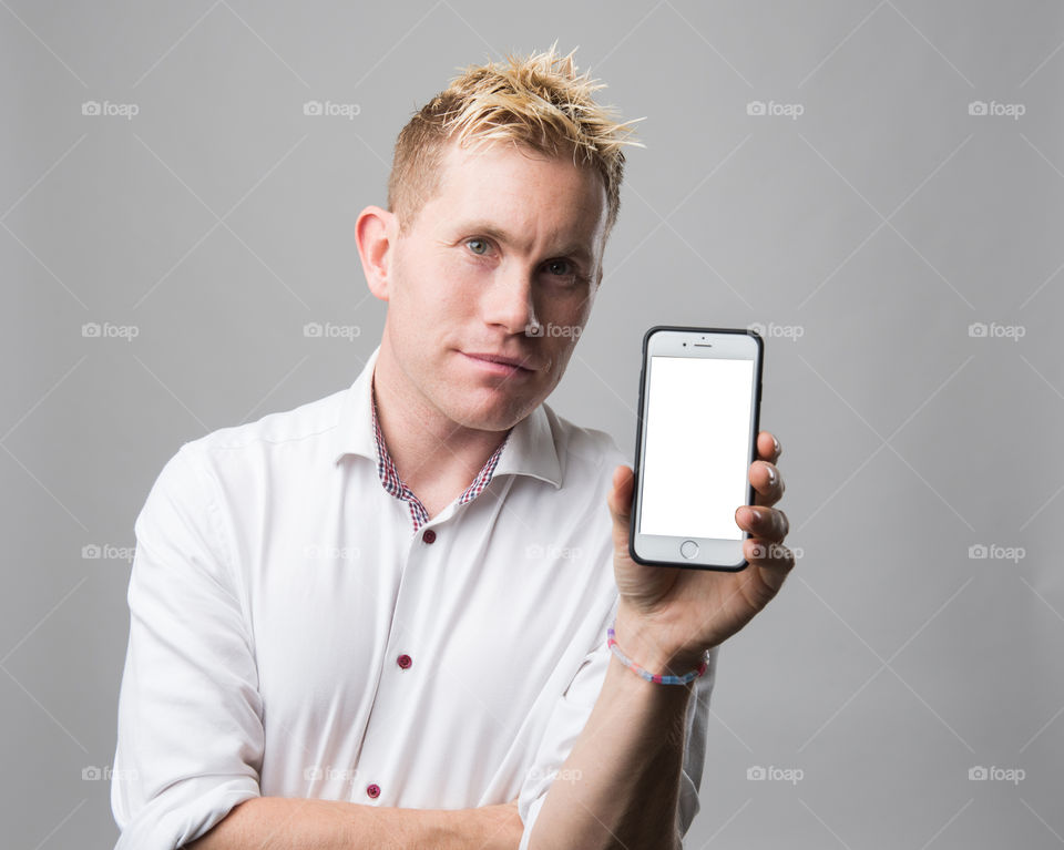 Happy man with cellular phone smiling and showing his phone.