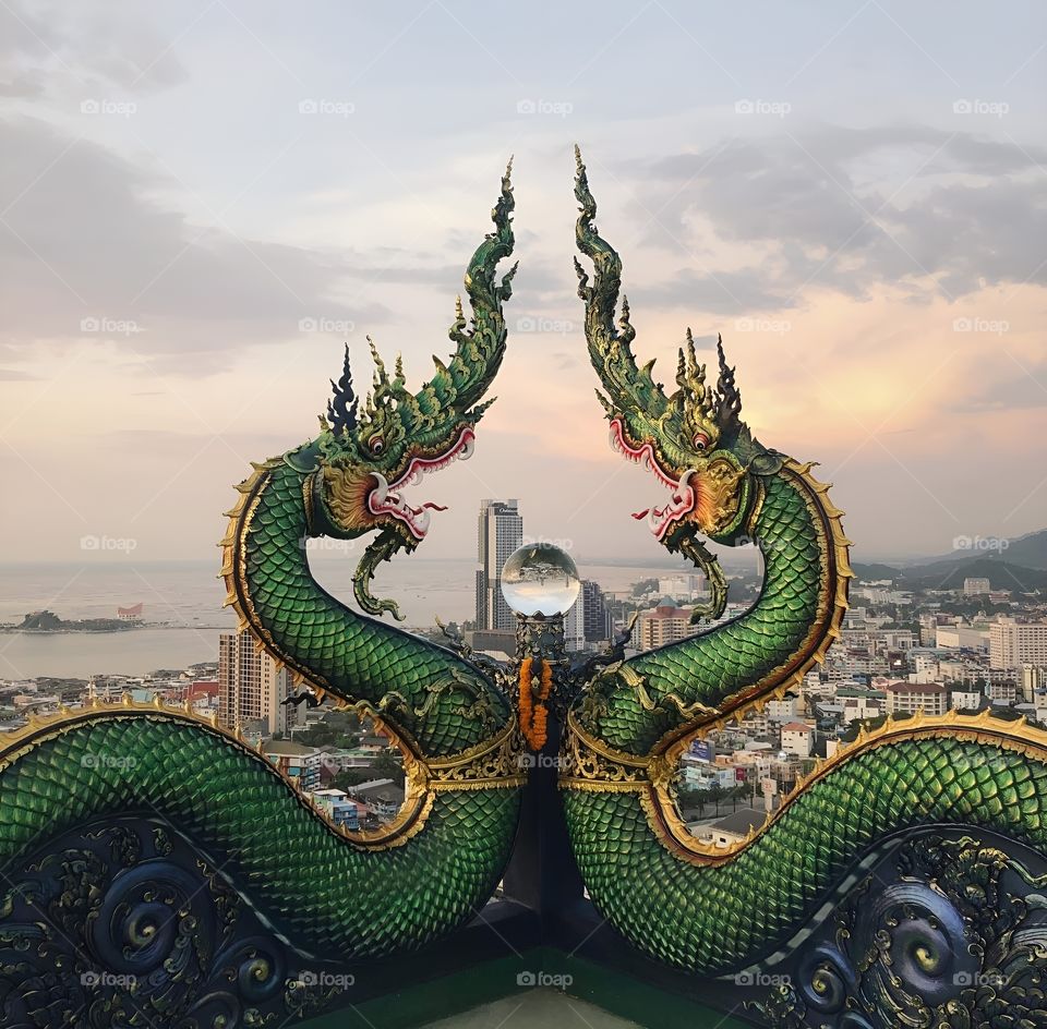 Big green snake statue on top of a building, Thailand, city view