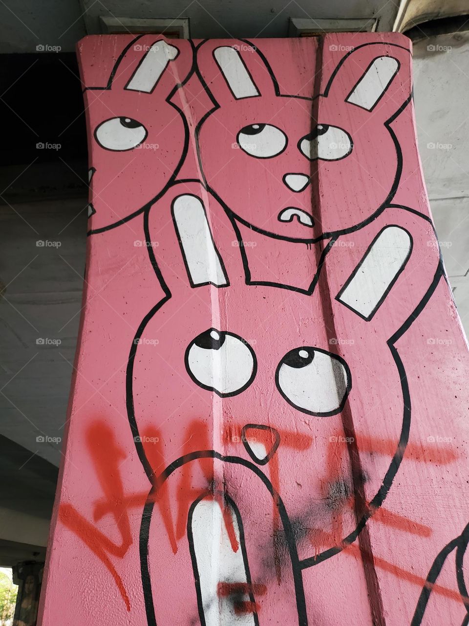 Street art : bunnies have a look of fear.  Graffiti word in red hate also may convey fear.