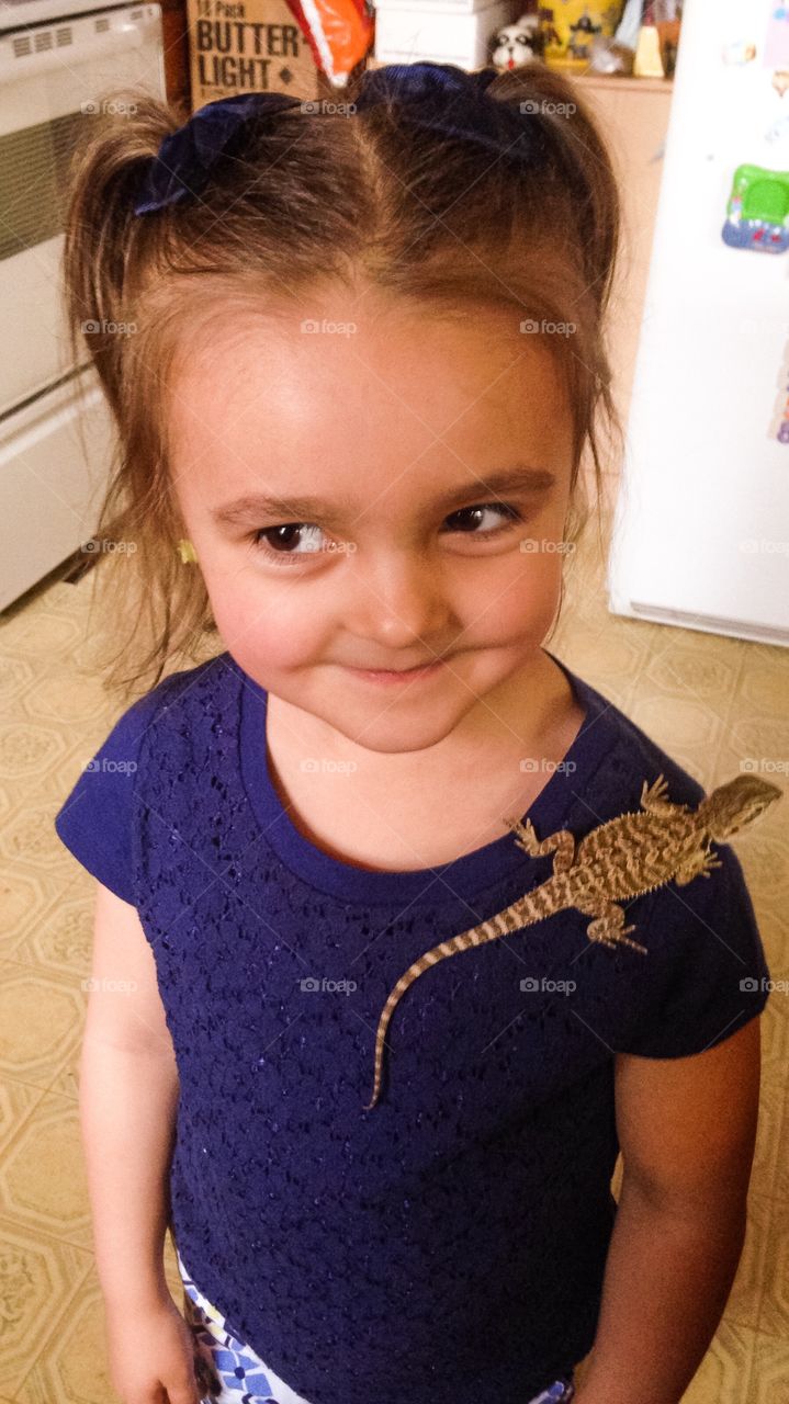 Lizard on smiling girl's shoulder